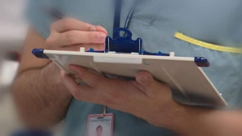 A doctor holds a clip board