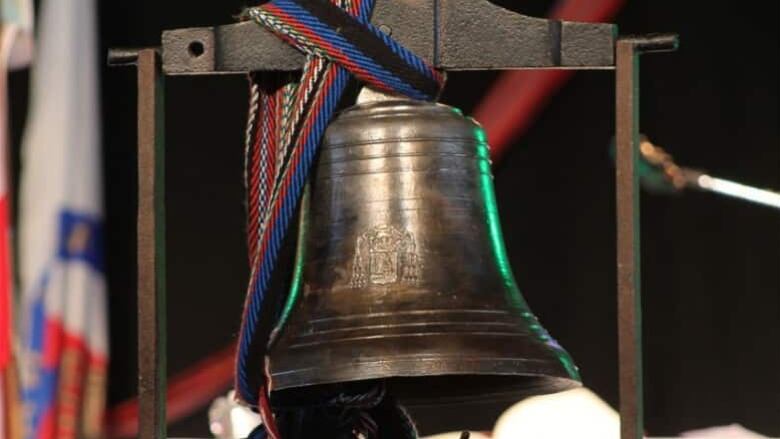 An old bell wrapped with a colourful ribbon.