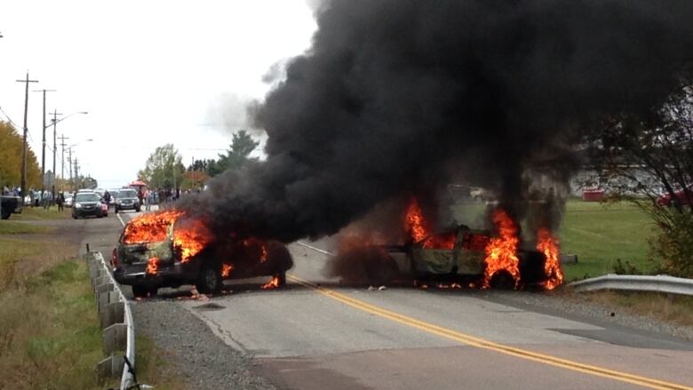 RCMP cruisers a blaze at the site of the 2013 clash.