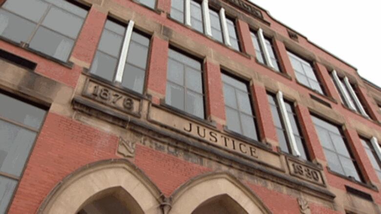 A red brick building with a plaque above the entryway that says 