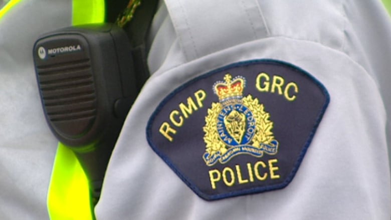 A shoulder patch showing the RCMP crest on a grey uniform.