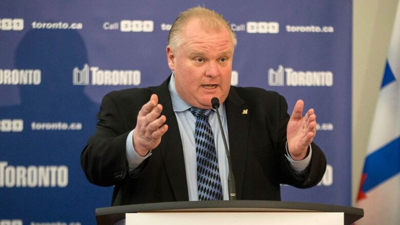 Man in a suit speaking at a podium