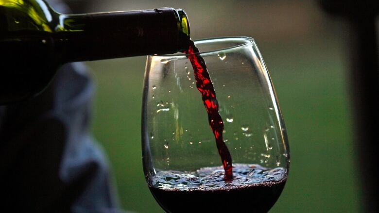 Red wine is poured from a bottle into a glass. 