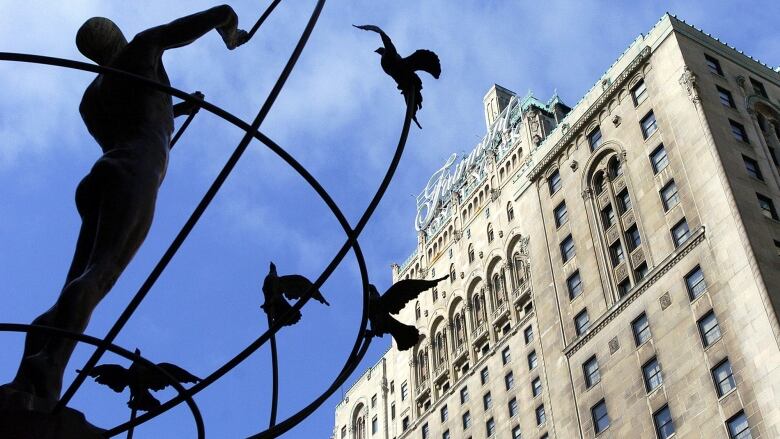 The Fairmont Royal York seen from a low angle with a statue in front of it.