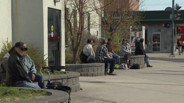 People sit on planters outside Yellowknife post office