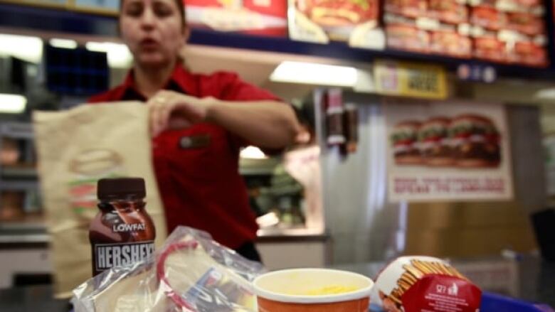 A cashier loading food items into bags.