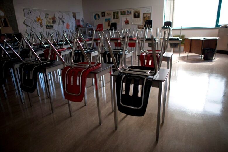 Rows of desks and chairs in an otherwise empty classroom.