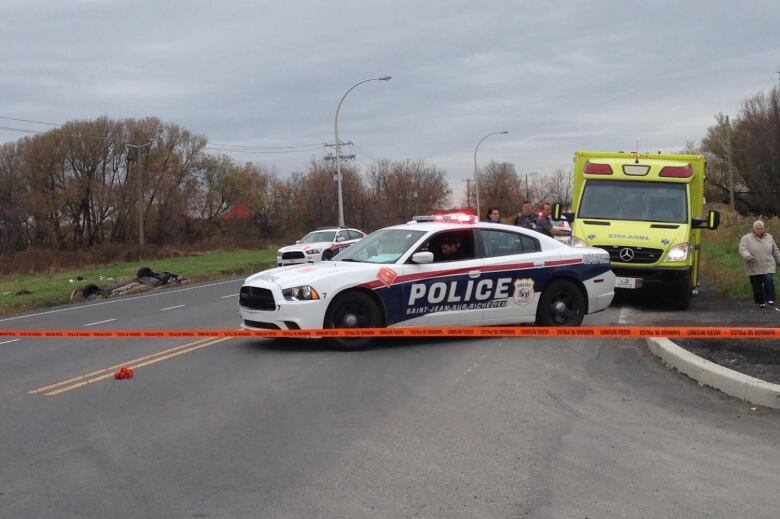 police cars on the road with car in a ditch