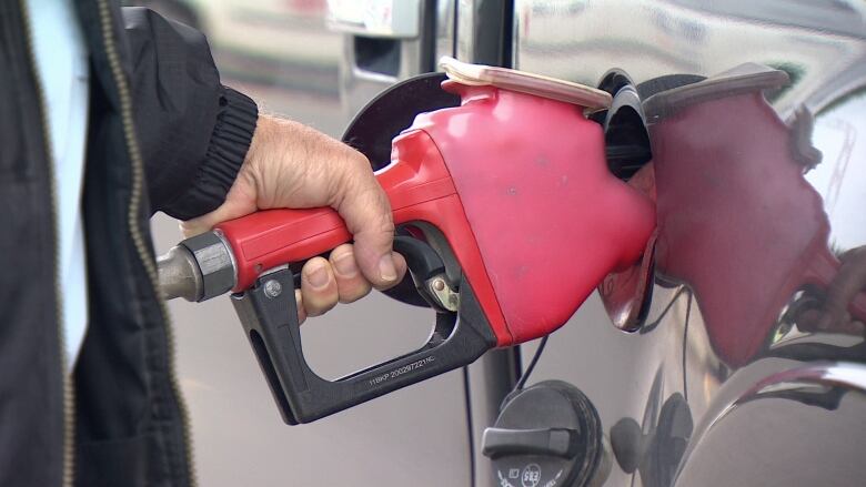 A man pumping gas.