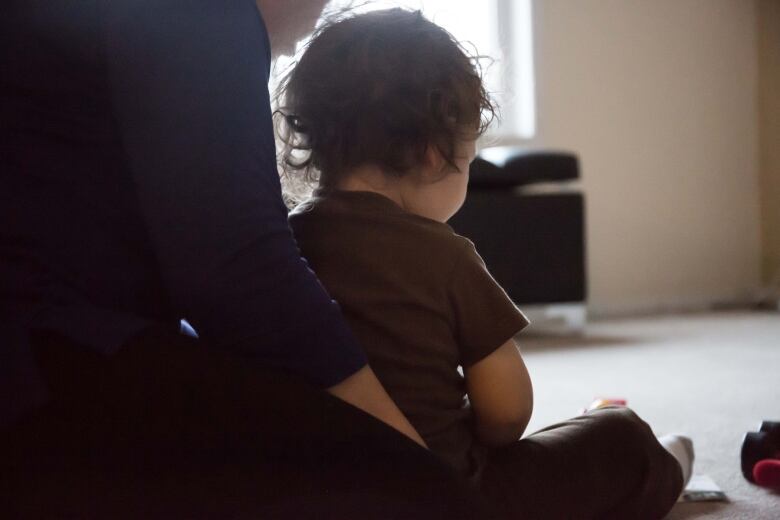 Young child sitting in woman's lap.