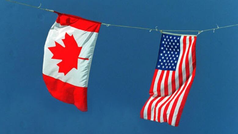 A Canadian flag and an American flag flying side by side. 