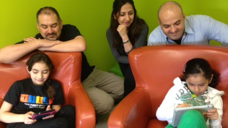 Parents observing the children looking at their mobile devices.