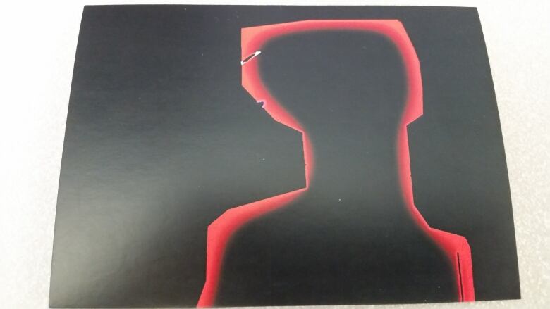 A painting by Noah Falk depicts a figure on a black background, outlined in red. He drew this picture the day after he got his first sunburn.  