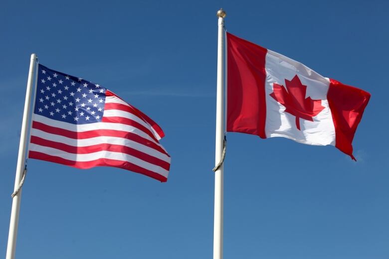 An American flag and Canadian flag fly side-by-side.