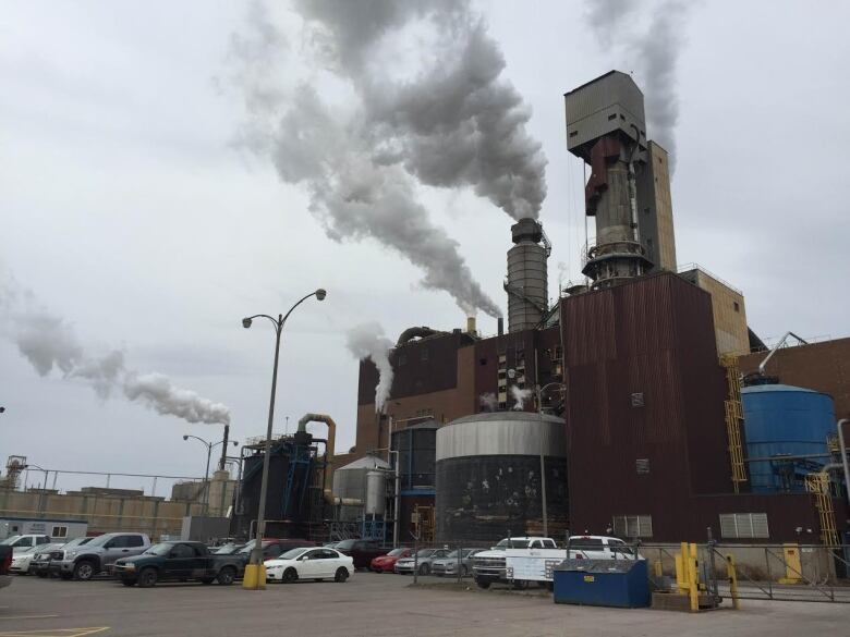 a building with smoke stacks on a cloudy day