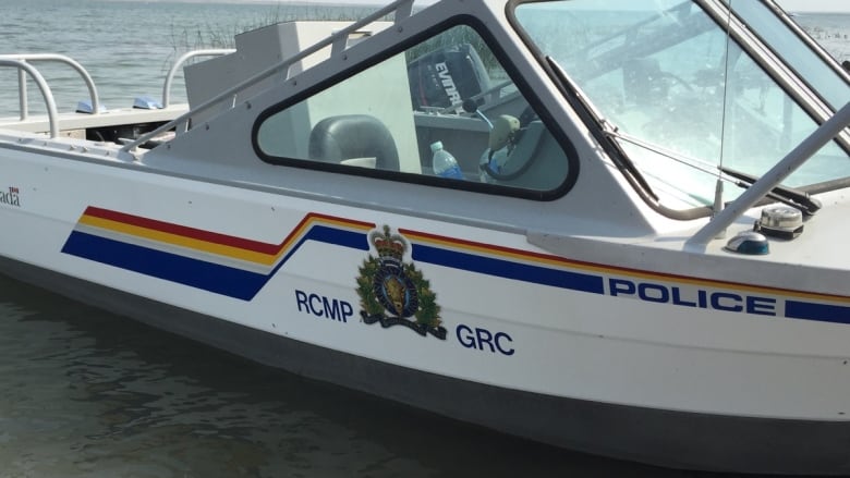 A boat with RCMP decals is seen floating on a body of water.