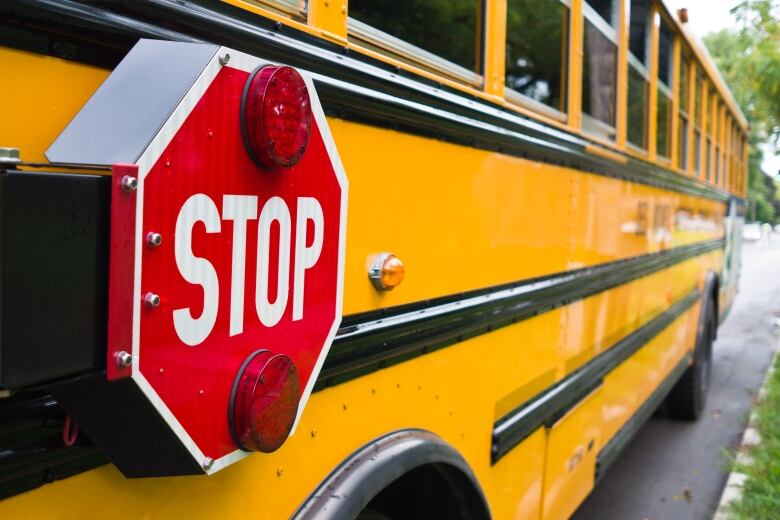 A picture of a yellow school bus stop sign.