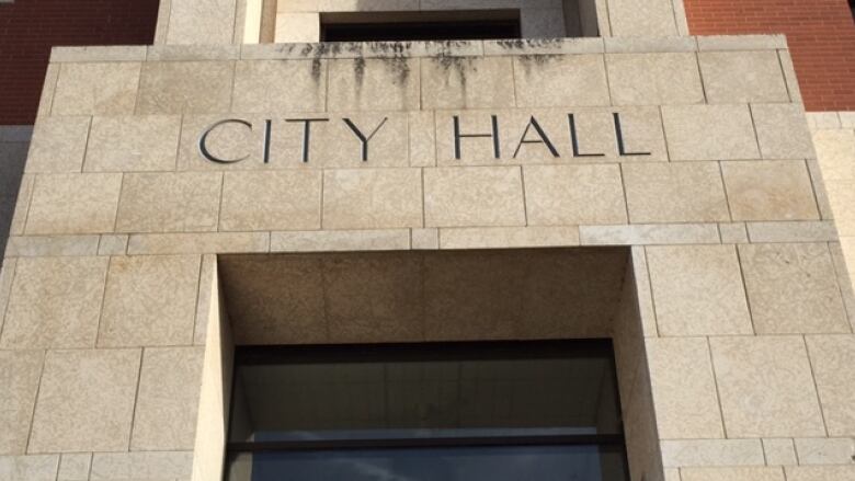 A grey bricked building labelled city hall.