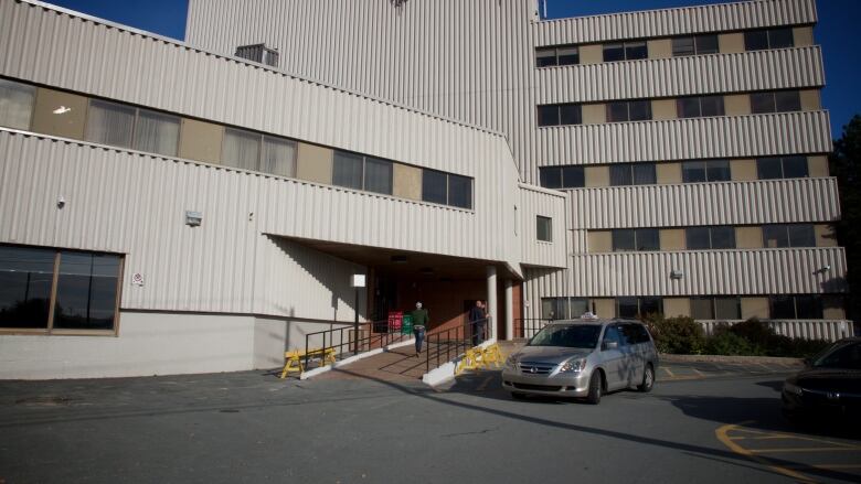 A multi-storey raw concrete building is shown.