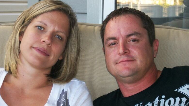 A woman with shoulder-length blond hair sits next to a man with short dark hair.