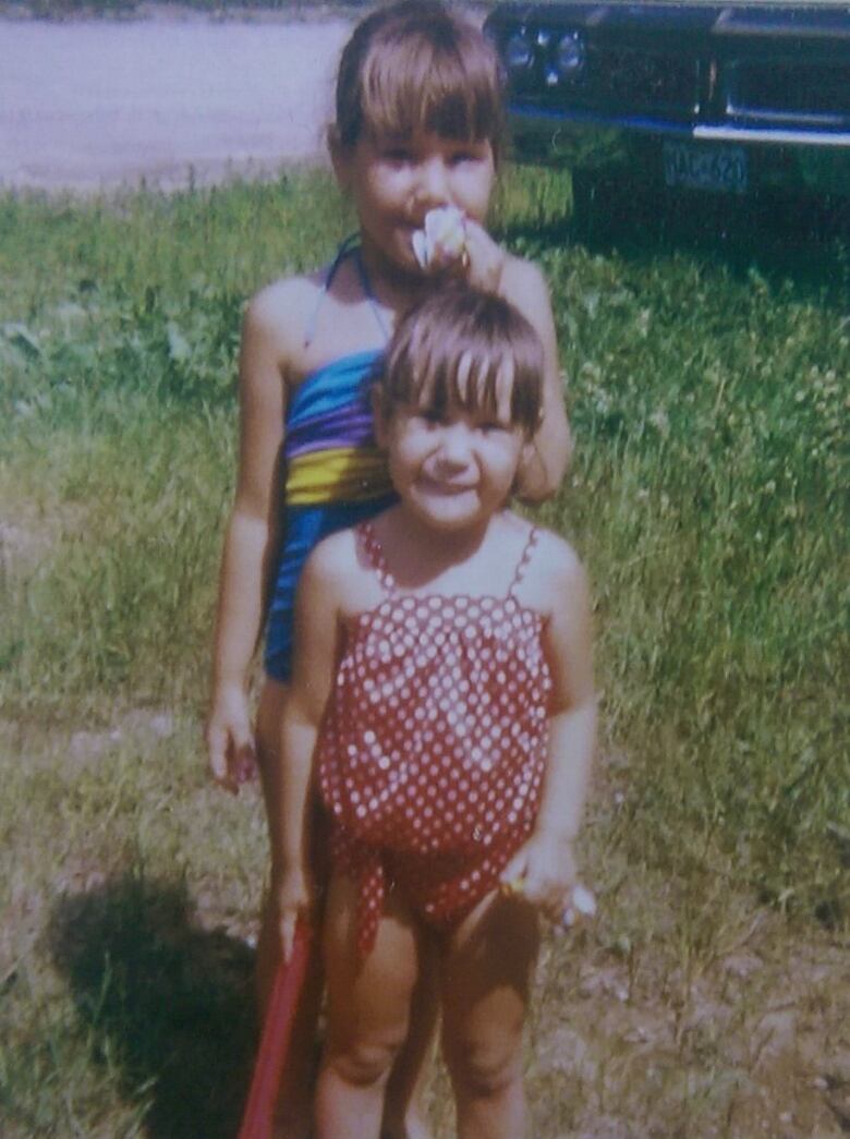 Two children posing for a picture on a summer day.