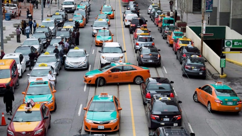 A congested city street full of taxis and other vehicles.