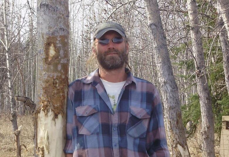 A man stands in a forest.