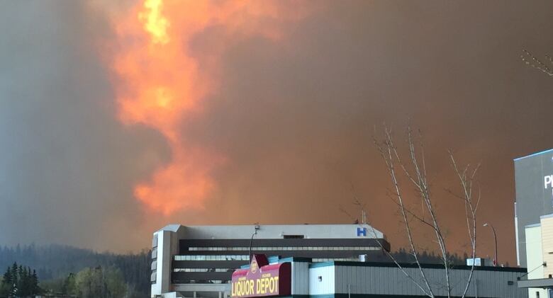 The Northern Lights Health Facility in Fort McMurray can be seen in this photo as flames shoot into the sky.