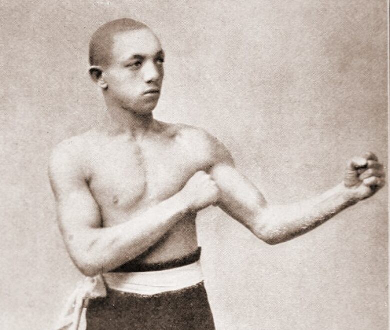 An old image of a Black boxer holding a fighting pose