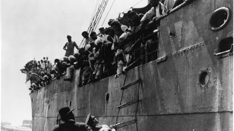 An archival picture shows hundreds of people gathered on a ship in a harbour.