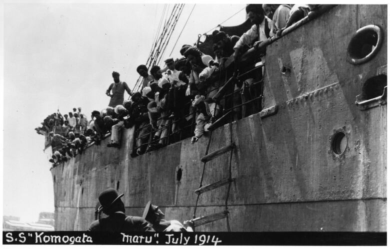 An archival picture shows hundreds of people gathered on a ship in a harbour.