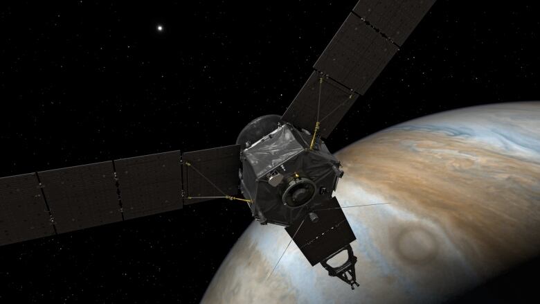 An illustration shows a spacecraft with long solar panels approaching Jupiter.