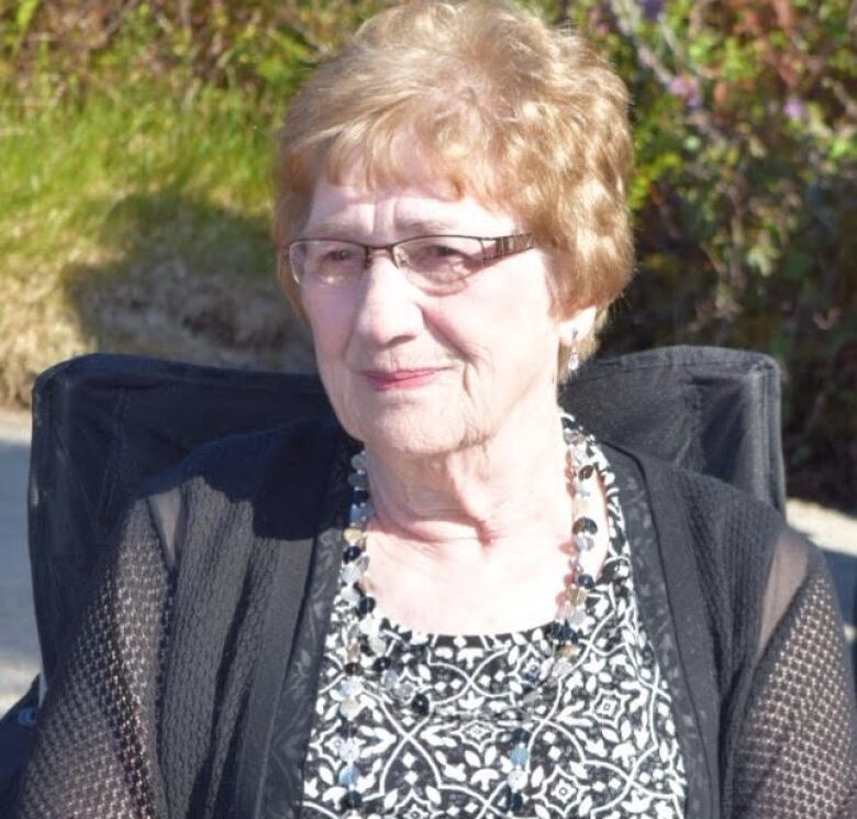 a portrait style photo of an older woman wearing glasses.