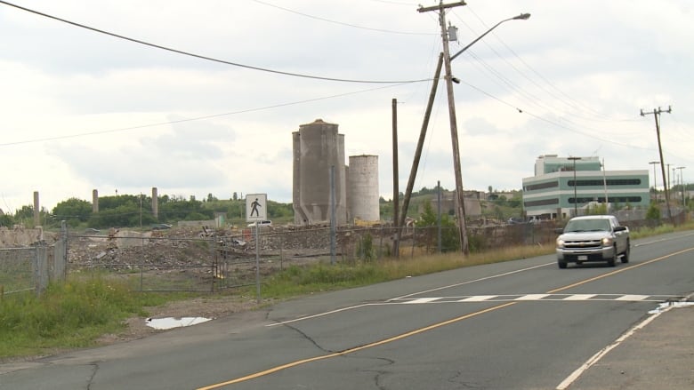 An empty site with old silos and building materials.