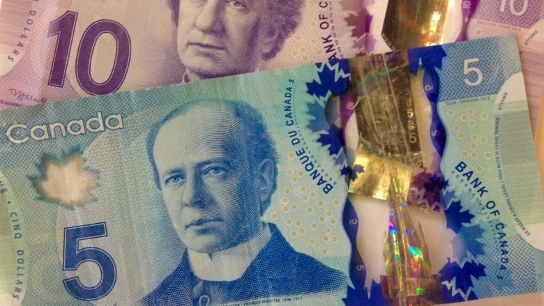 A $10 bill and $5 bill are shown