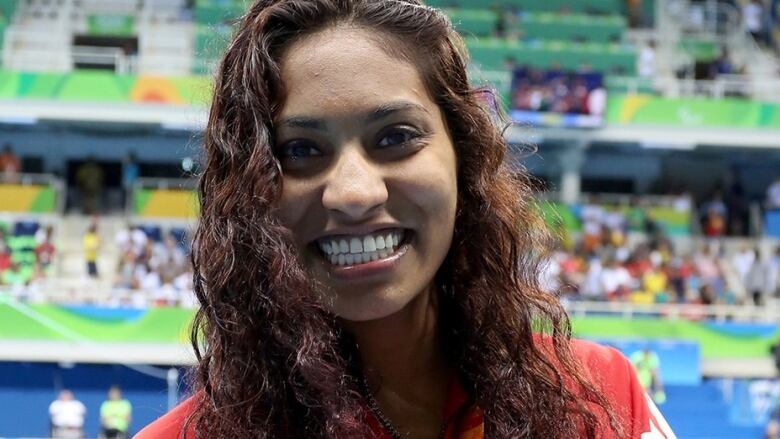 A woman with long brown hair smiles.