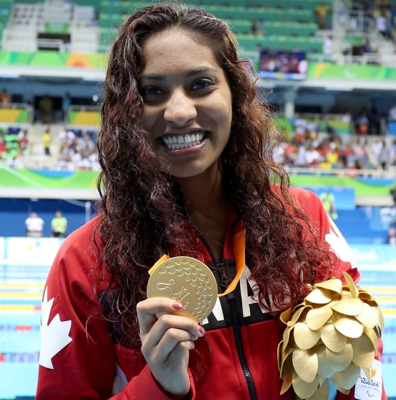 A woman with long brown hair smiles.