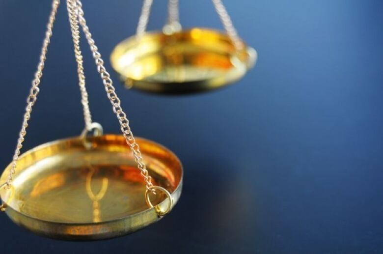 Two golden scales in front of a blue background 