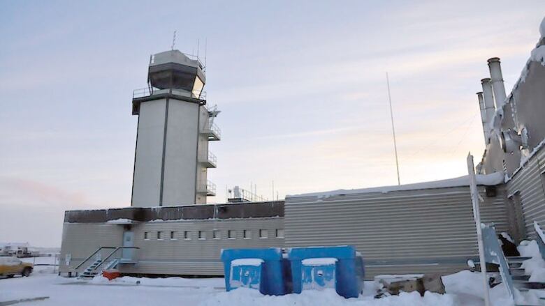 A watch tower in a building on a snowy day. 