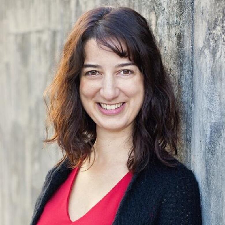 A woman with long dark hair smiling. 