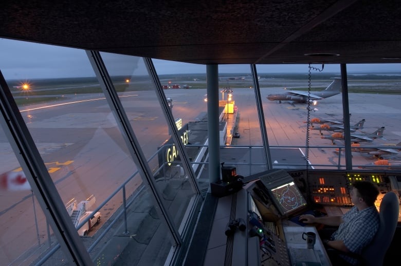 A control tower at an airport overlooking the runway. 