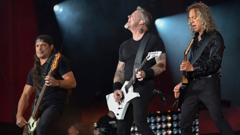 FILE - In this Sept. 24, 2016, file photo, musicians Robert Trujillo, left, James Hetfield and Kirk Hammett of Metallica perform at the 2016 Global Citizen Festival in Central Park in New York. Metallica joined Jimmy Fallon and The Roots for a toy instrument rendition of its hit, 