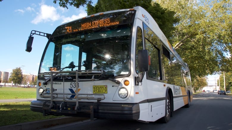 A transit bus is seen driving down a Halifax street with the Common visible in the background.