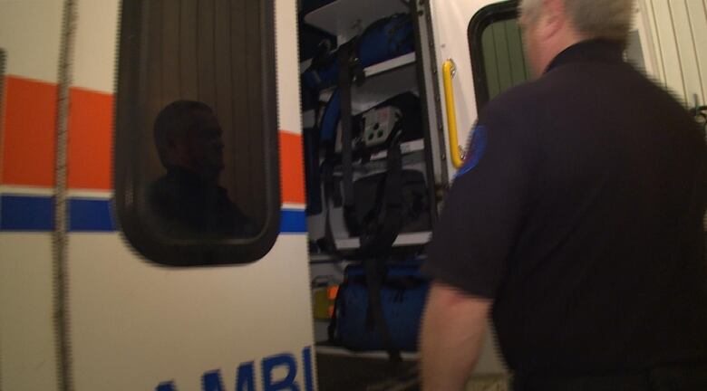 Paramedic entering ambulance though a side door.