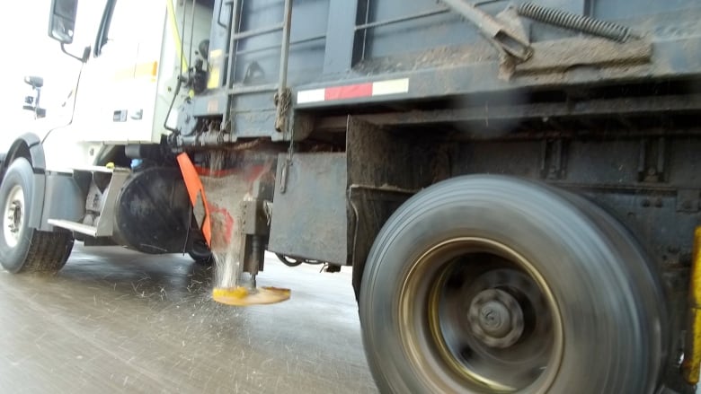 A close up on salt coming off a truck 