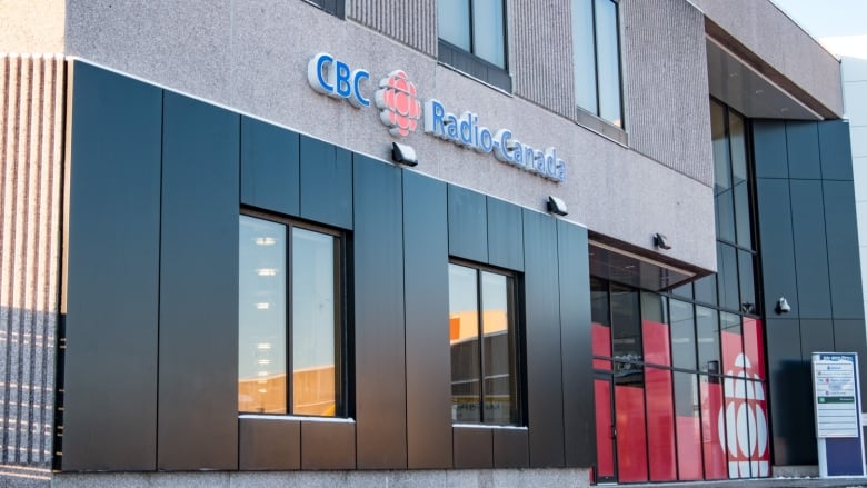 CBC building with the red and white logo in the windows. and CBC Radio-Canada side attached to the bricks above.