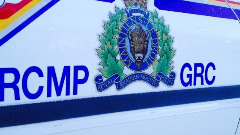 The words RCMP and GRC are affixed to the side of a police cruiser, with the RCMP logo in between 