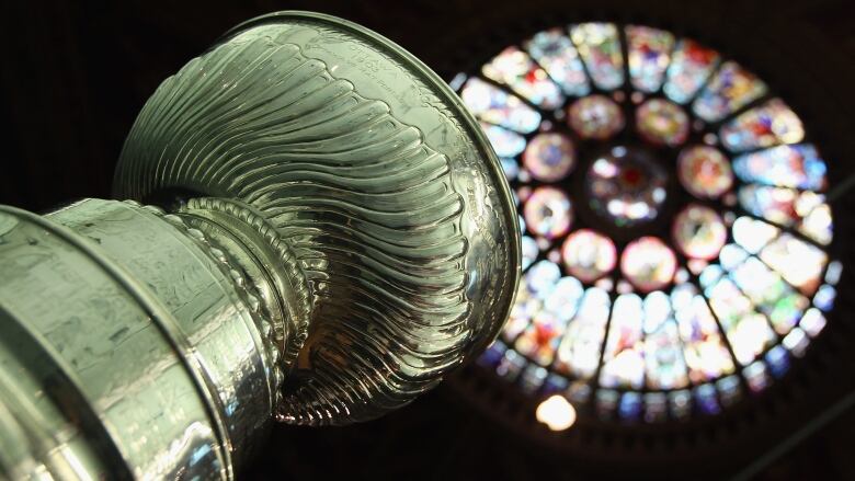 The top of the Stanley Cup is shown, with a stained glass ceiling pictured above it.