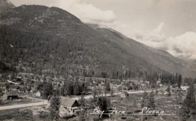 An old black and white photo of a camp in a valley.