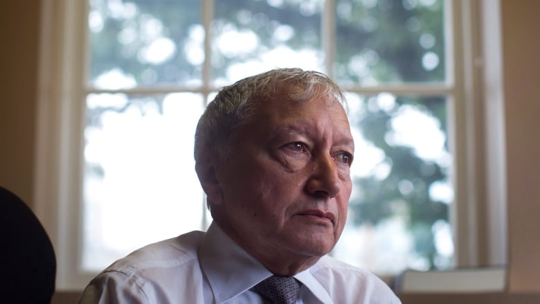 A man sits in front of a window